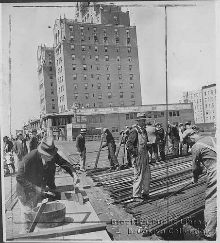 Boardwalk Repairs in 1934: Group of men ripping up old planking on Coney Island boardwalk near Half Moon Hotel. Brooklyn Public Library, Brooklyn Collection Boardwalk renovation 1934